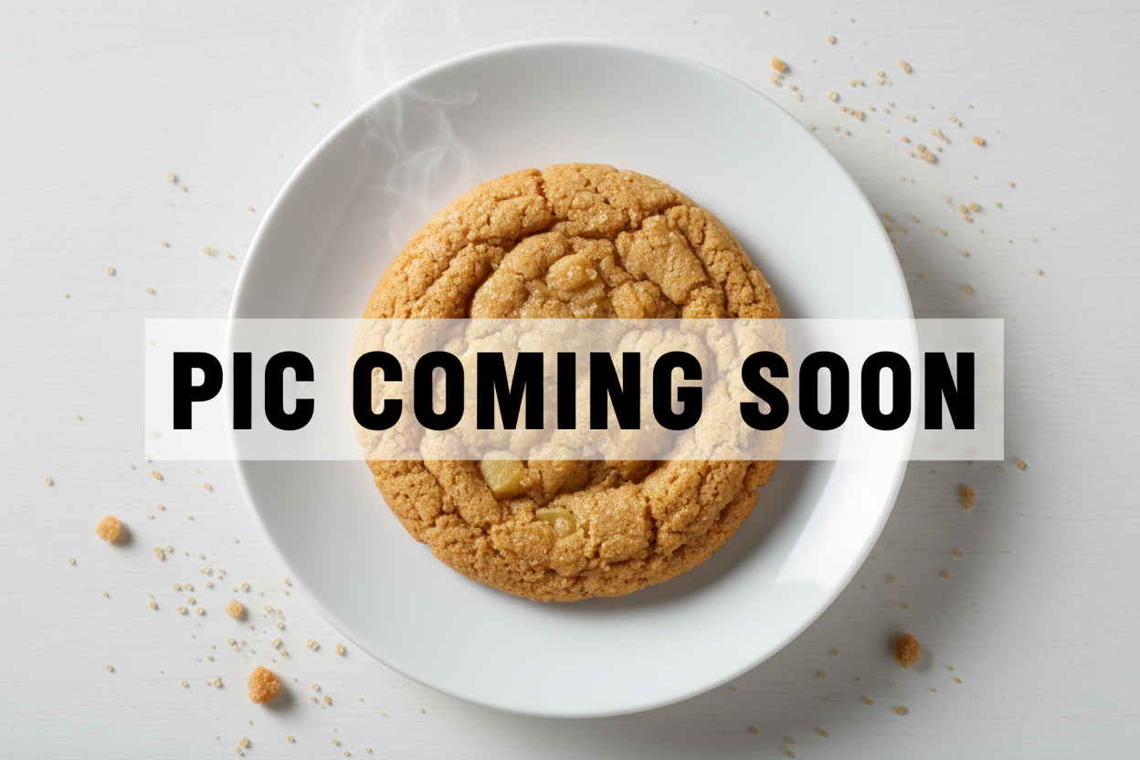 Show an overhead pickture of a chewy ginger shot cookie on a white plate, sitting on a whote table. Over top of the image write "PIC COMING SOON"