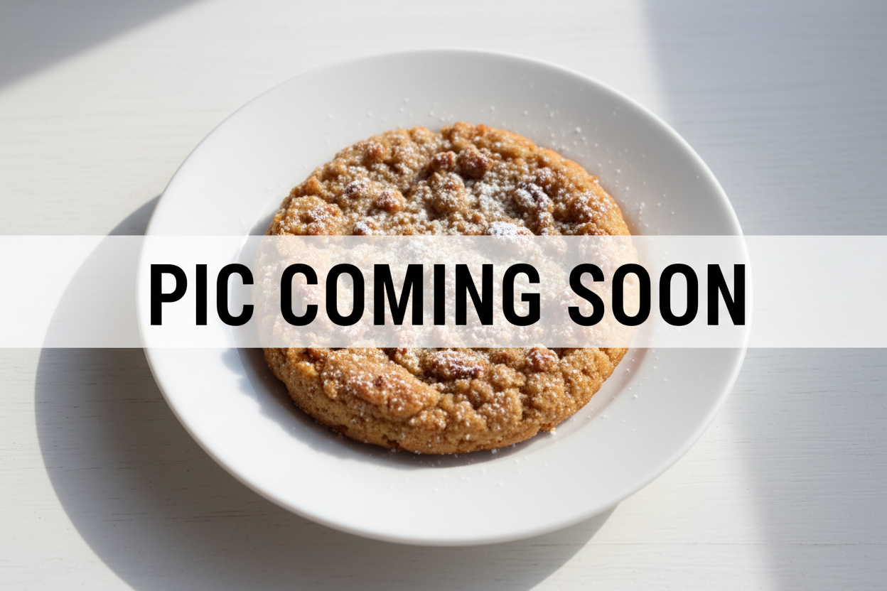 design an overhead pic of a pecan streusal cookie on a white plate and white table with the words PIC COMING SOON over top